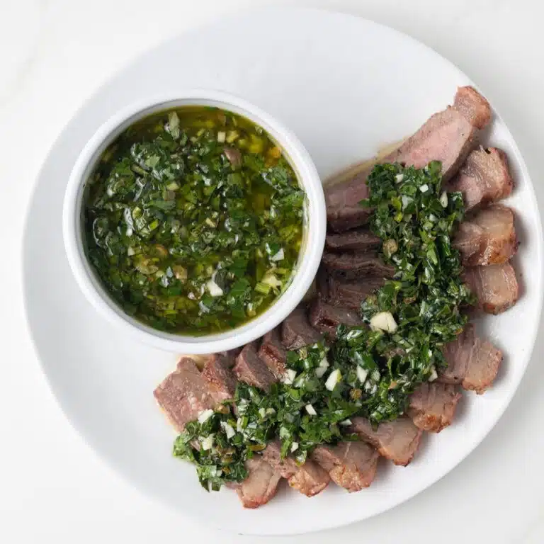 Herb caper sauce drizzled over steak slices.