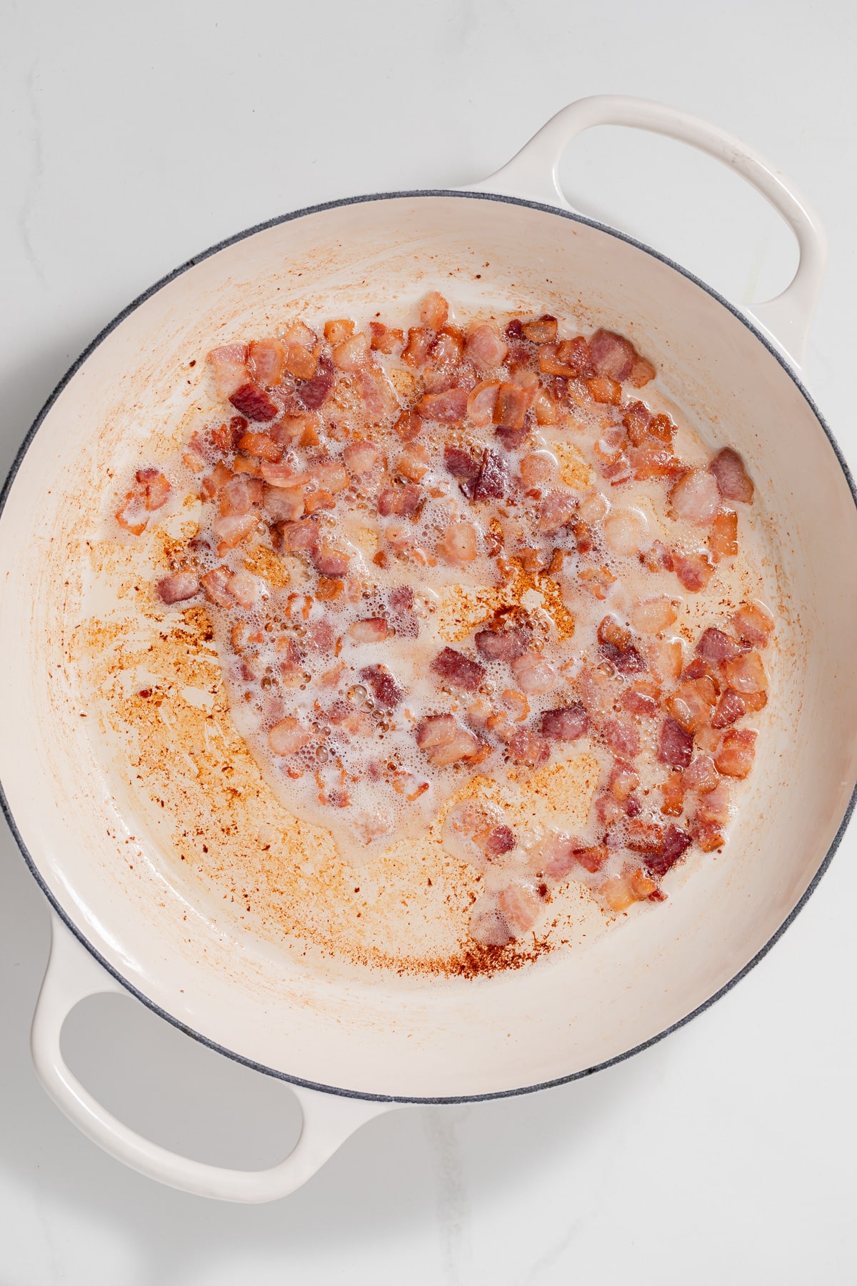 Cooked bacon pieces in a pan.