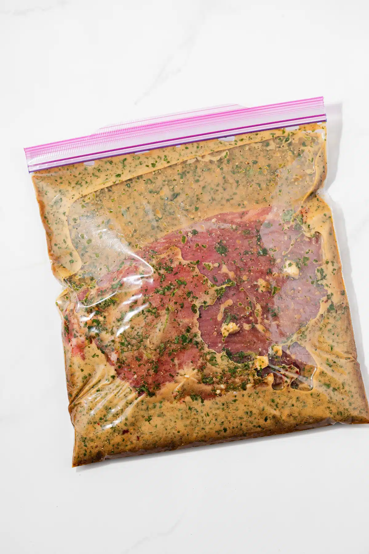 Steak with carne asada marinade in zip top bag.