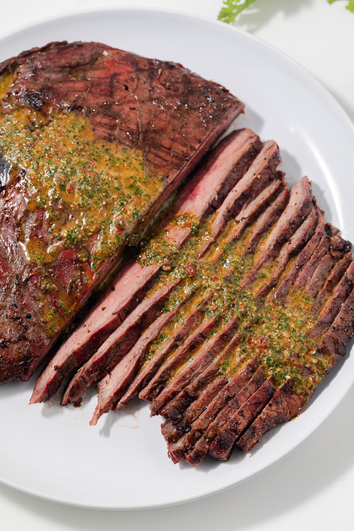 Carne asada marinated steak sliced on a white plate.