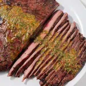 Carne asada marinated steak sliced on a white plate.