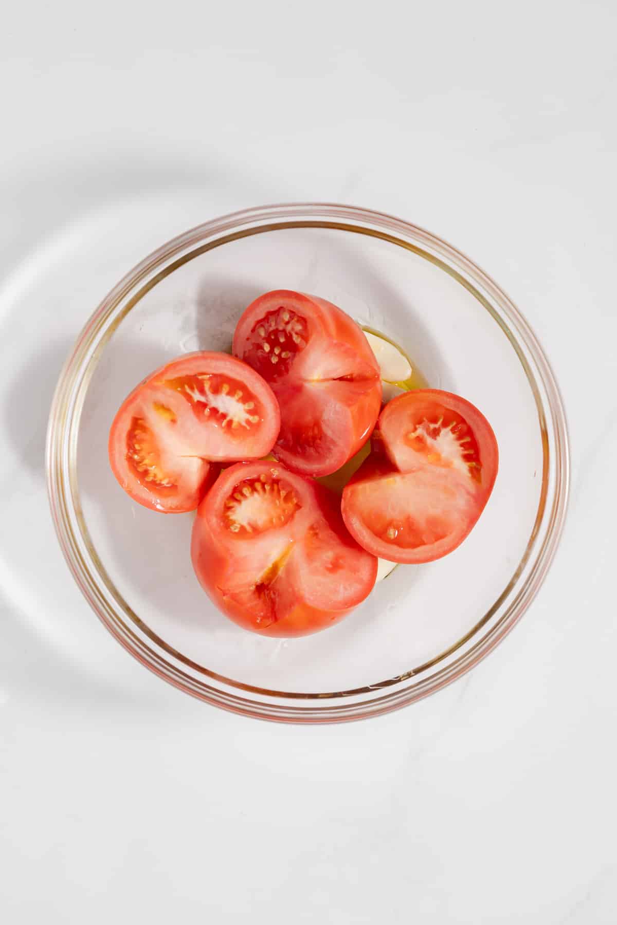 Tomatoes and garlic in glass bowl.