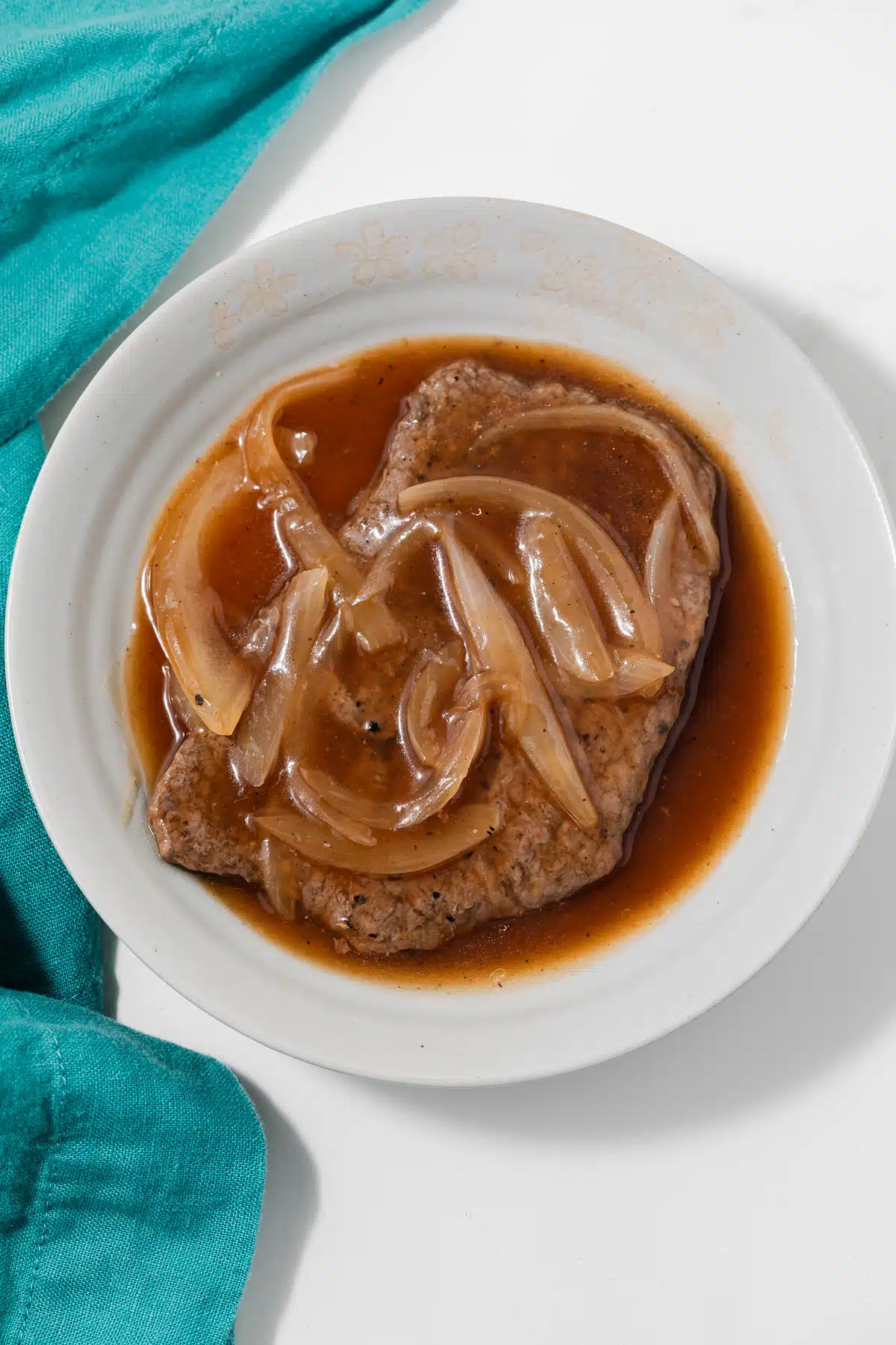 Bowl with salisbury steak sauce covering a steak.