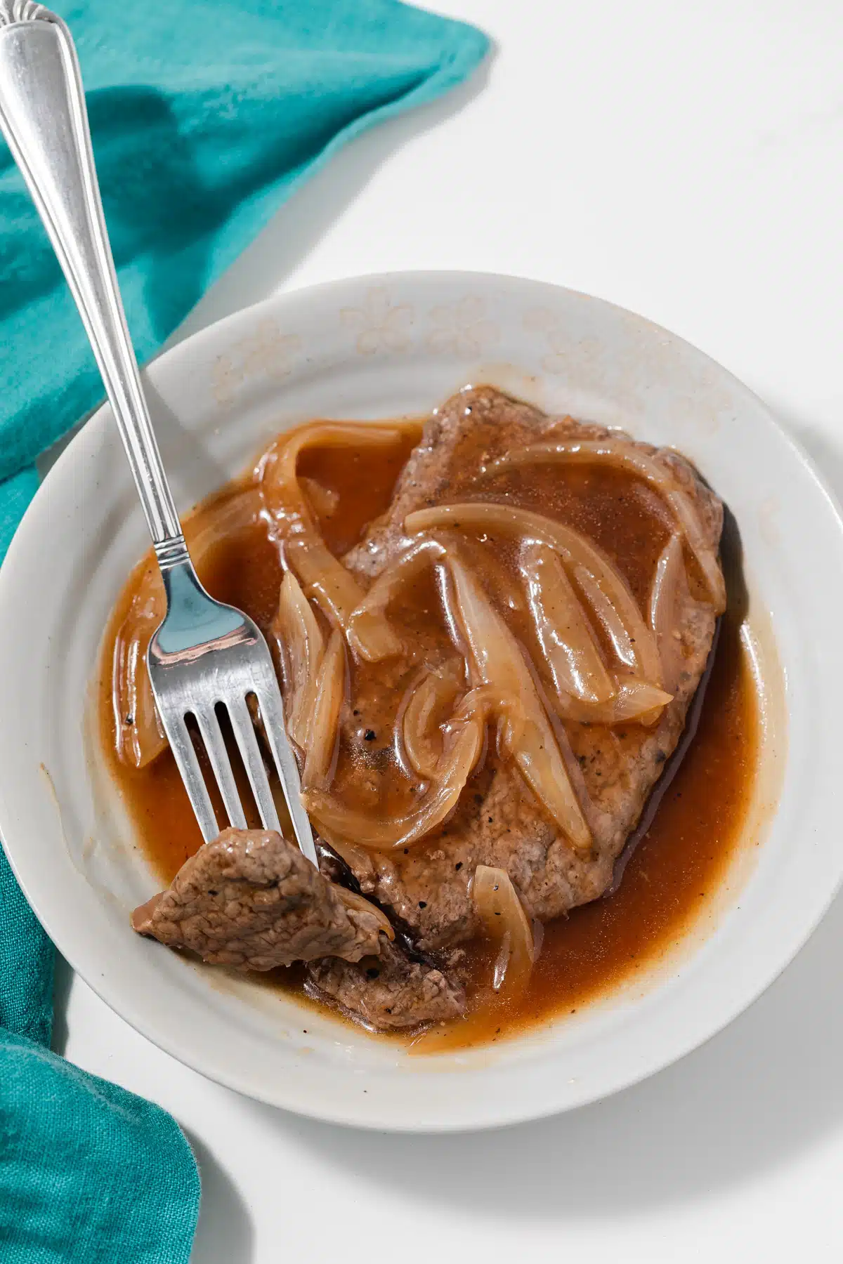 Fork taking a bite out of salisbury steak.