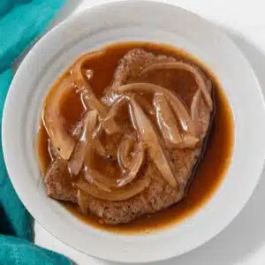 Bowl with salisbury steak sauce covering a steak.