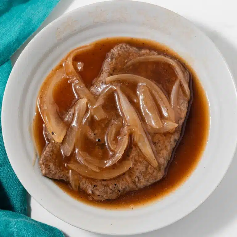 Bowl with salisbury steak sauce covering a steak.