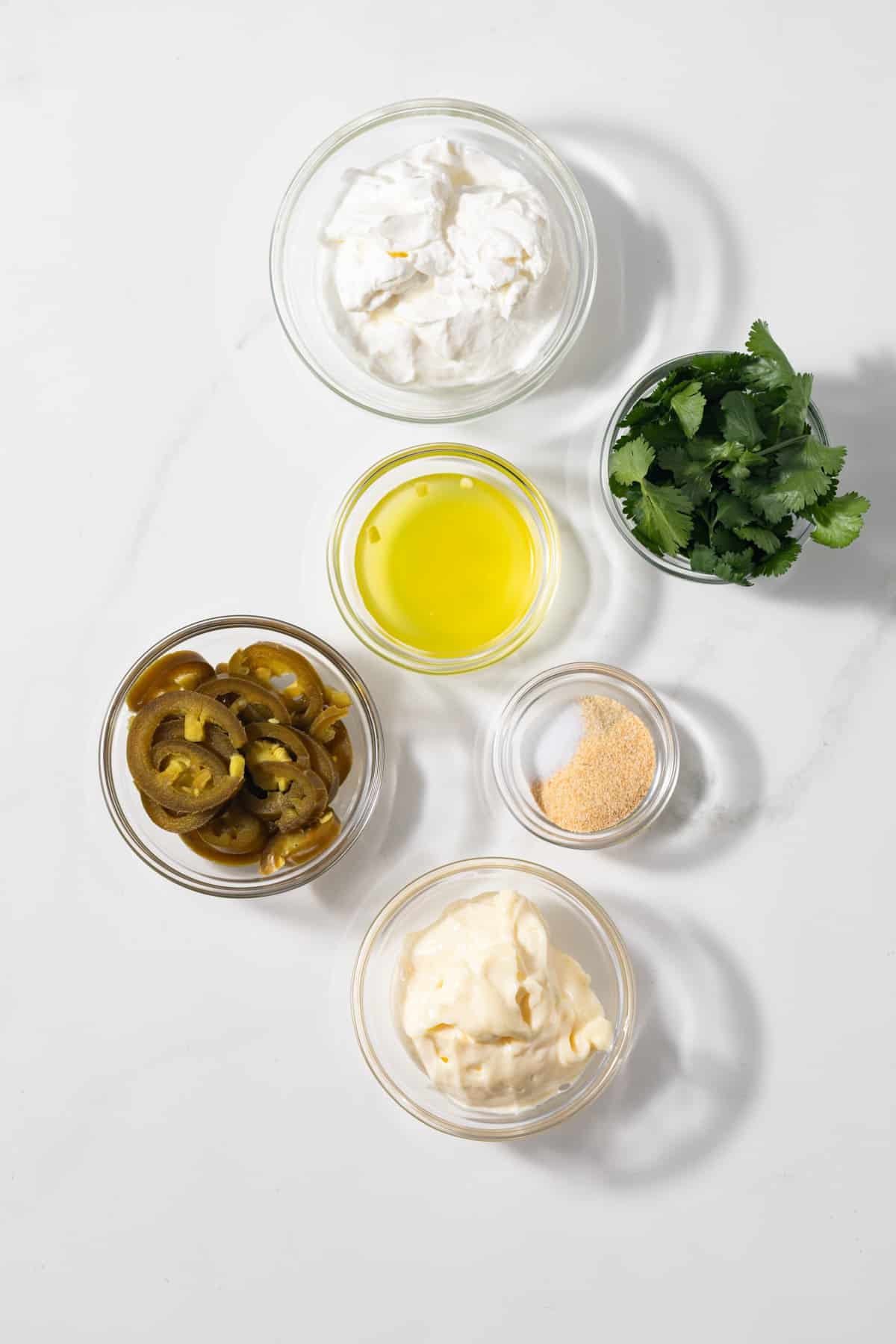 Ingredients for creamy jalapeno sauce in glass bowls.