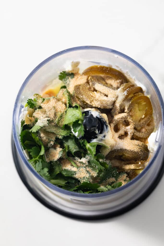Ingredients for creamy jalapeno sauce in a food processor.