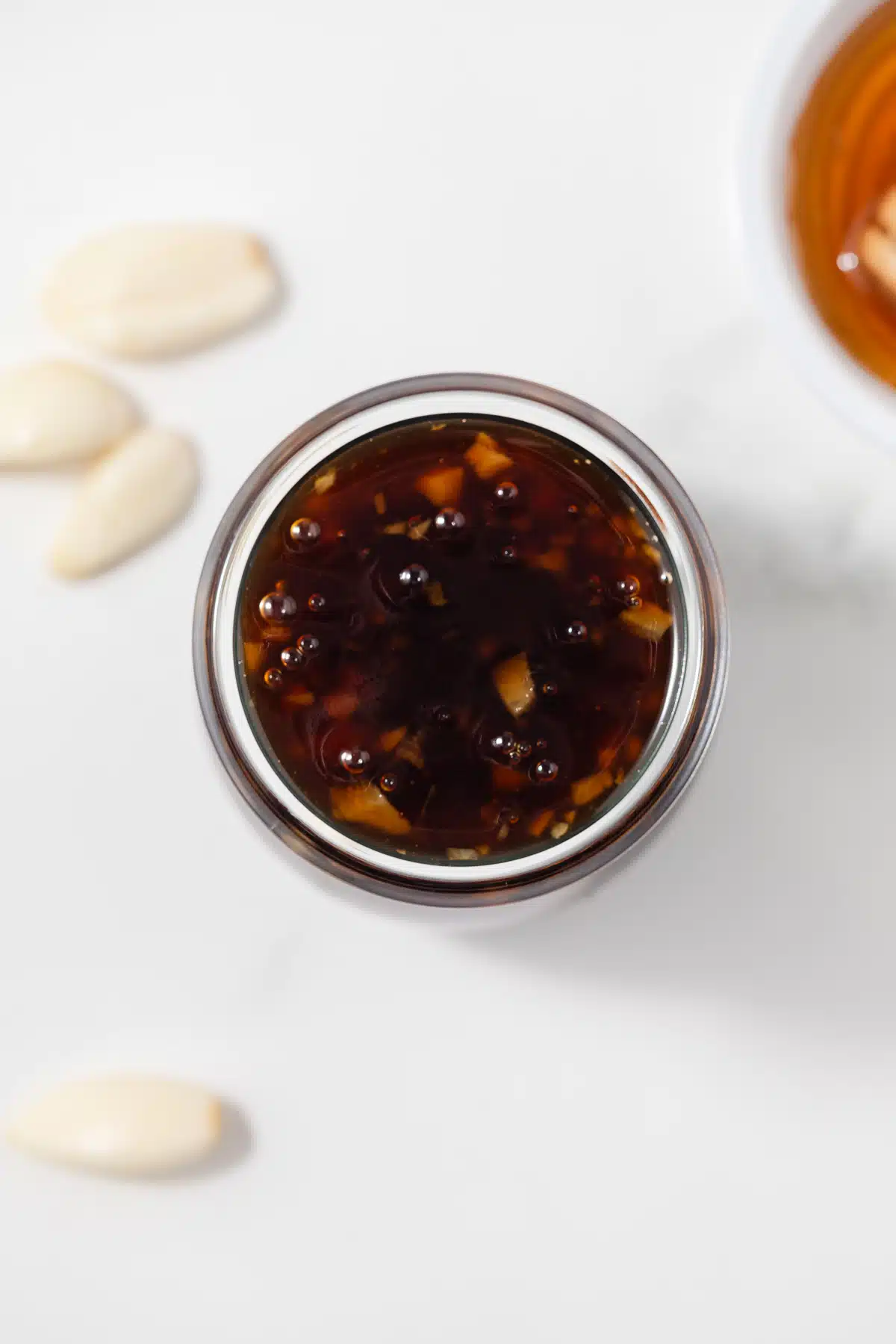 Overhead view of honey garlic sauce in glass jar.