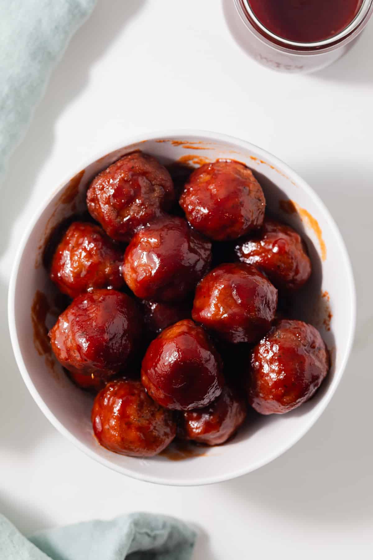 Glazed meatballs in white bowl.