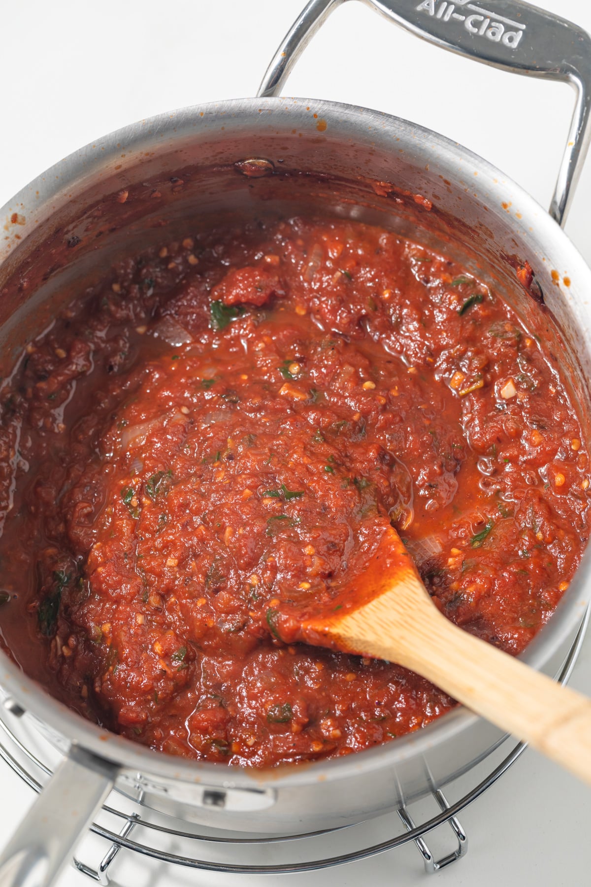 Arrabbiata sauce in a sauce pan with wooden spoon.