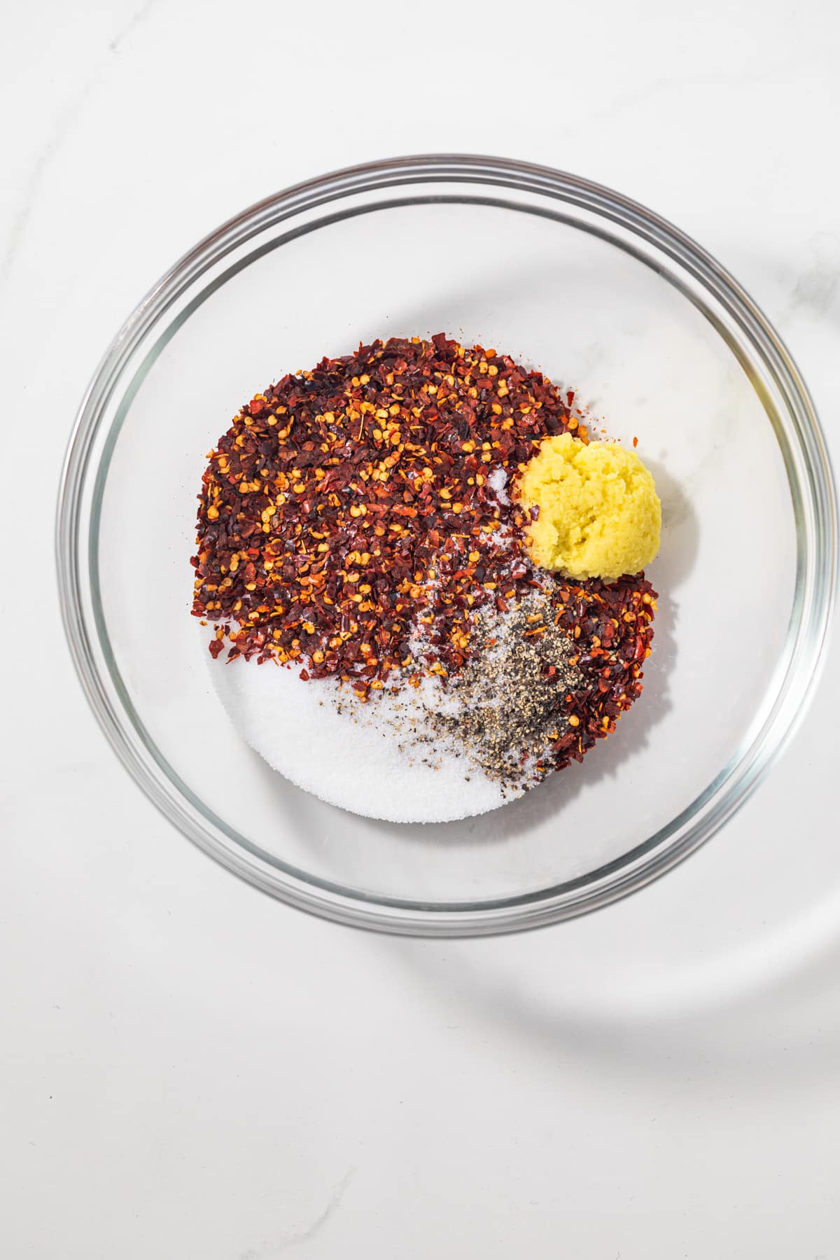 Crushed red pepper flakes with sugar and ginger in a bowl.