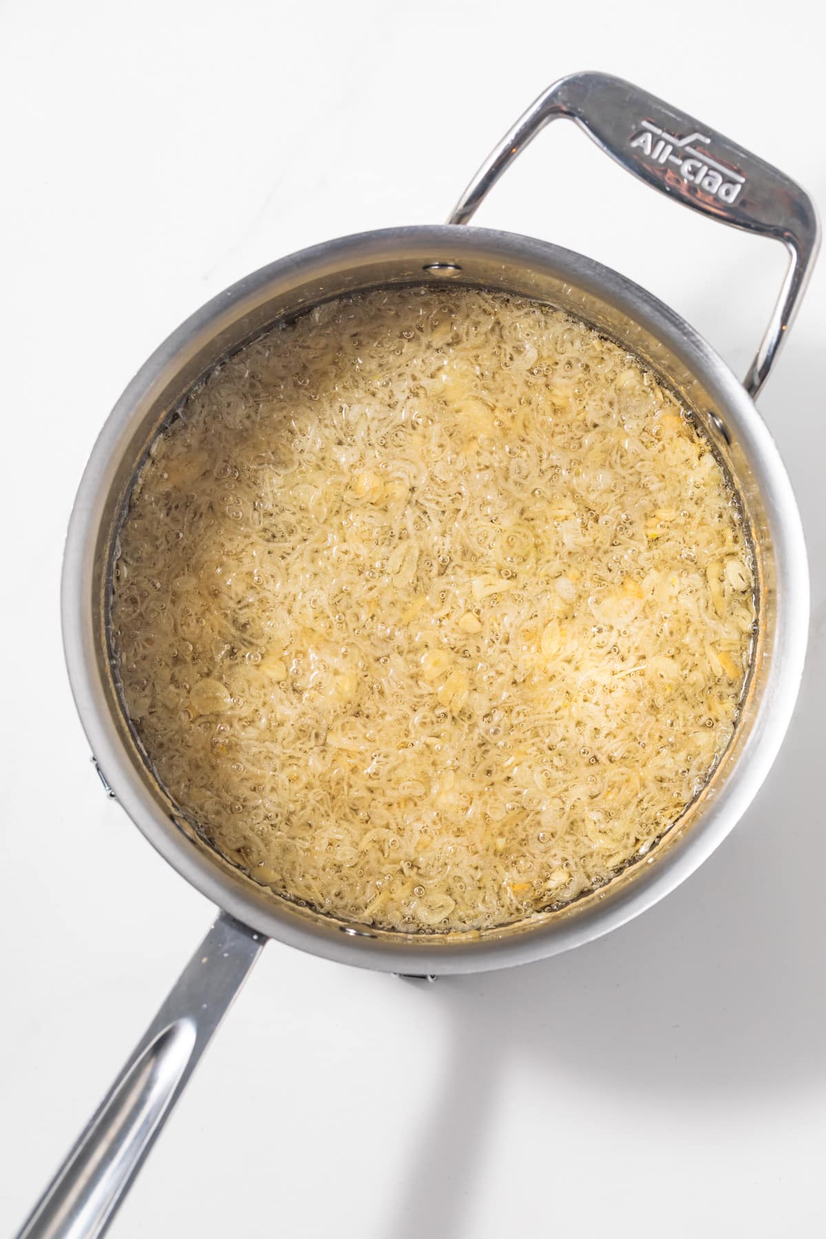 Fried shallots and garlic in a saucepan with oil.