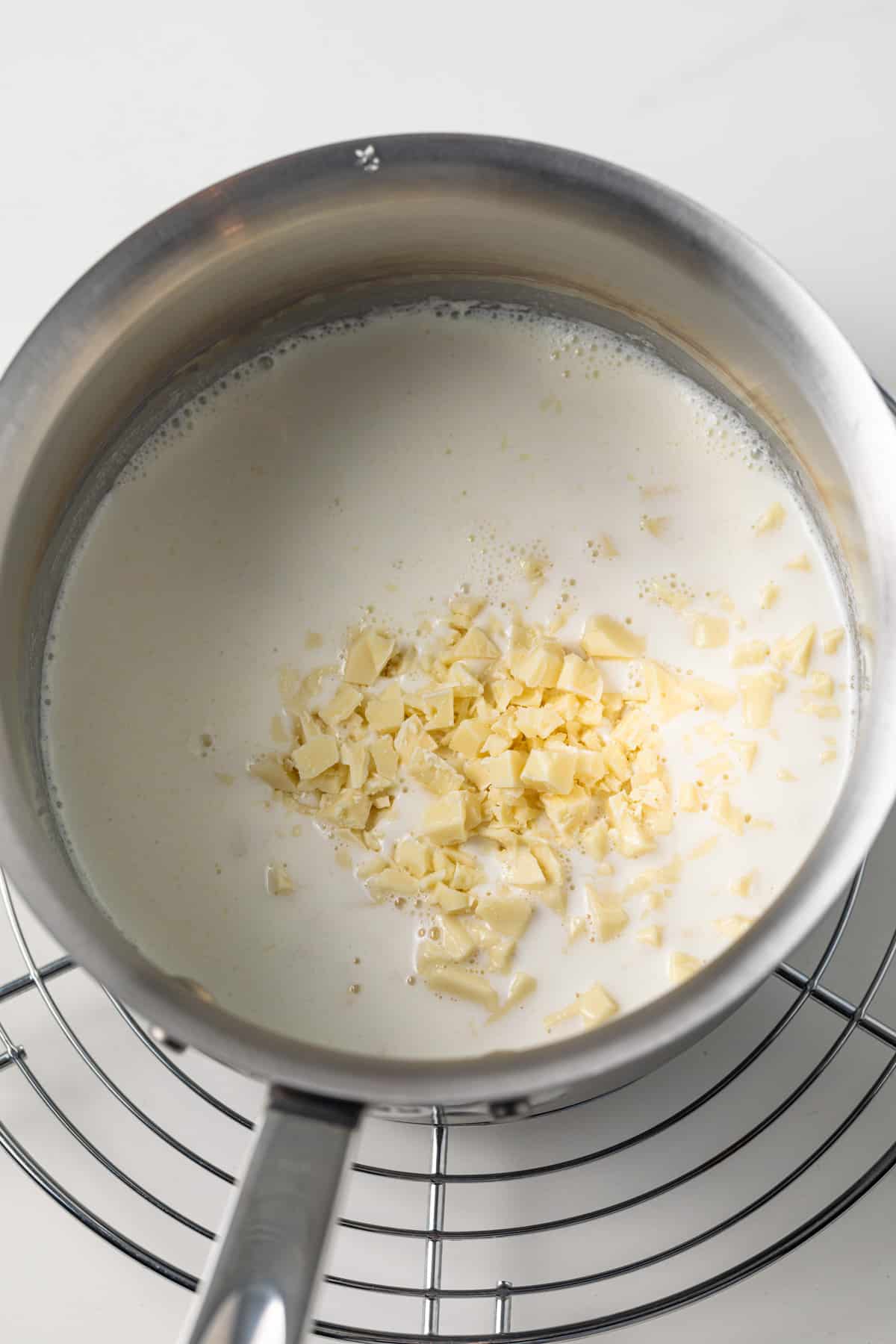 Half and half in a saucepan with chopped white chocolate.