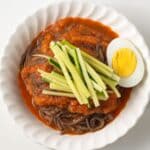 Overhead of Korean spicy cold noodles in a white bowls.