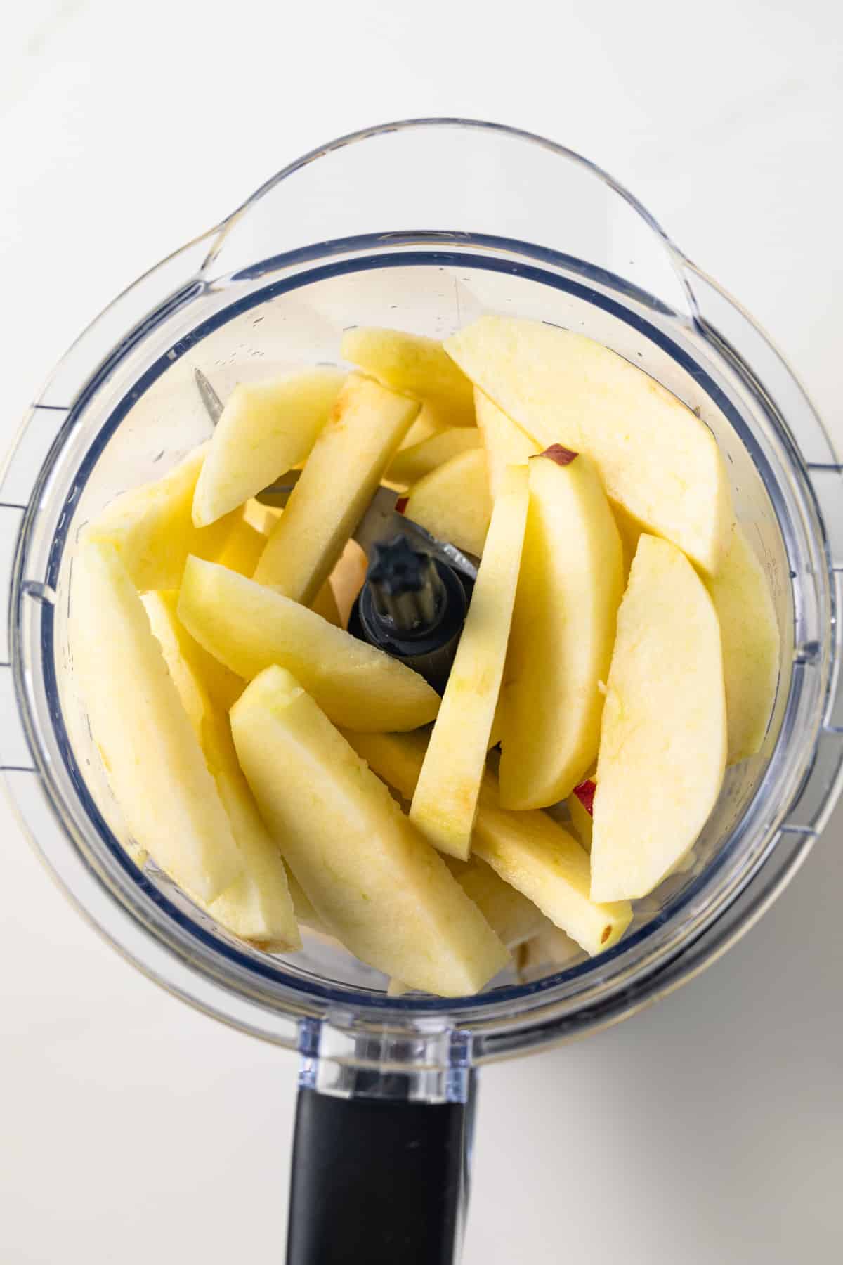 Sliced apples in a food processor.