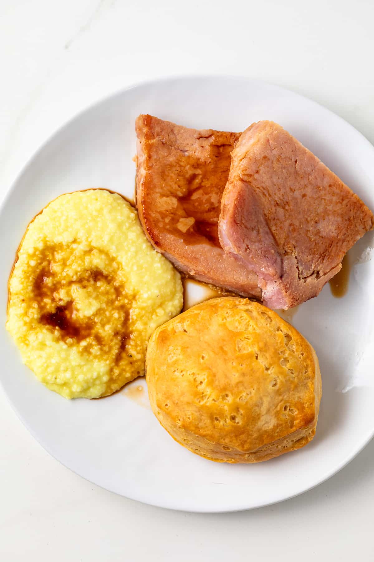 Ham, grits, and biscuit drizzled with red eye gravy.