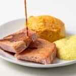 Red eye gravy poured over ham on plate.