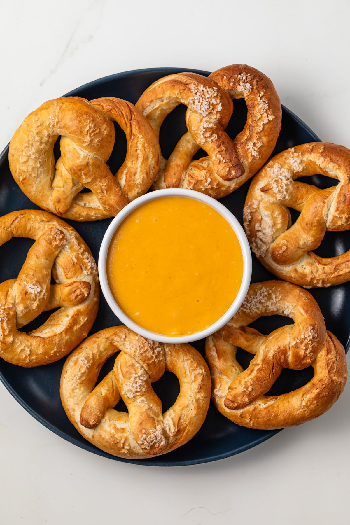 Overhead view of bowl of beer cheese surrounded by pretzels.