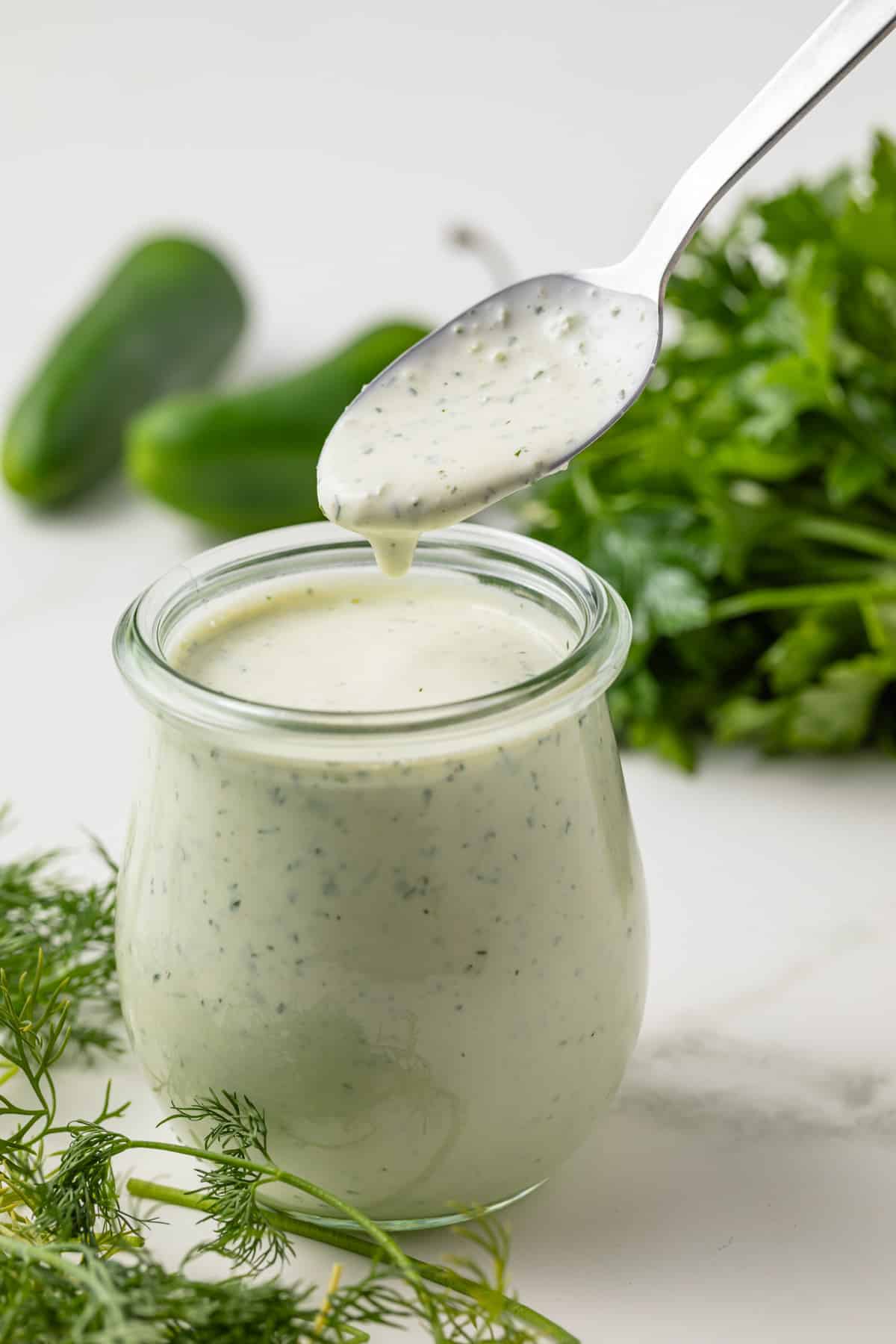 Jalapeno ranch dressing in a glass jar with spoon.