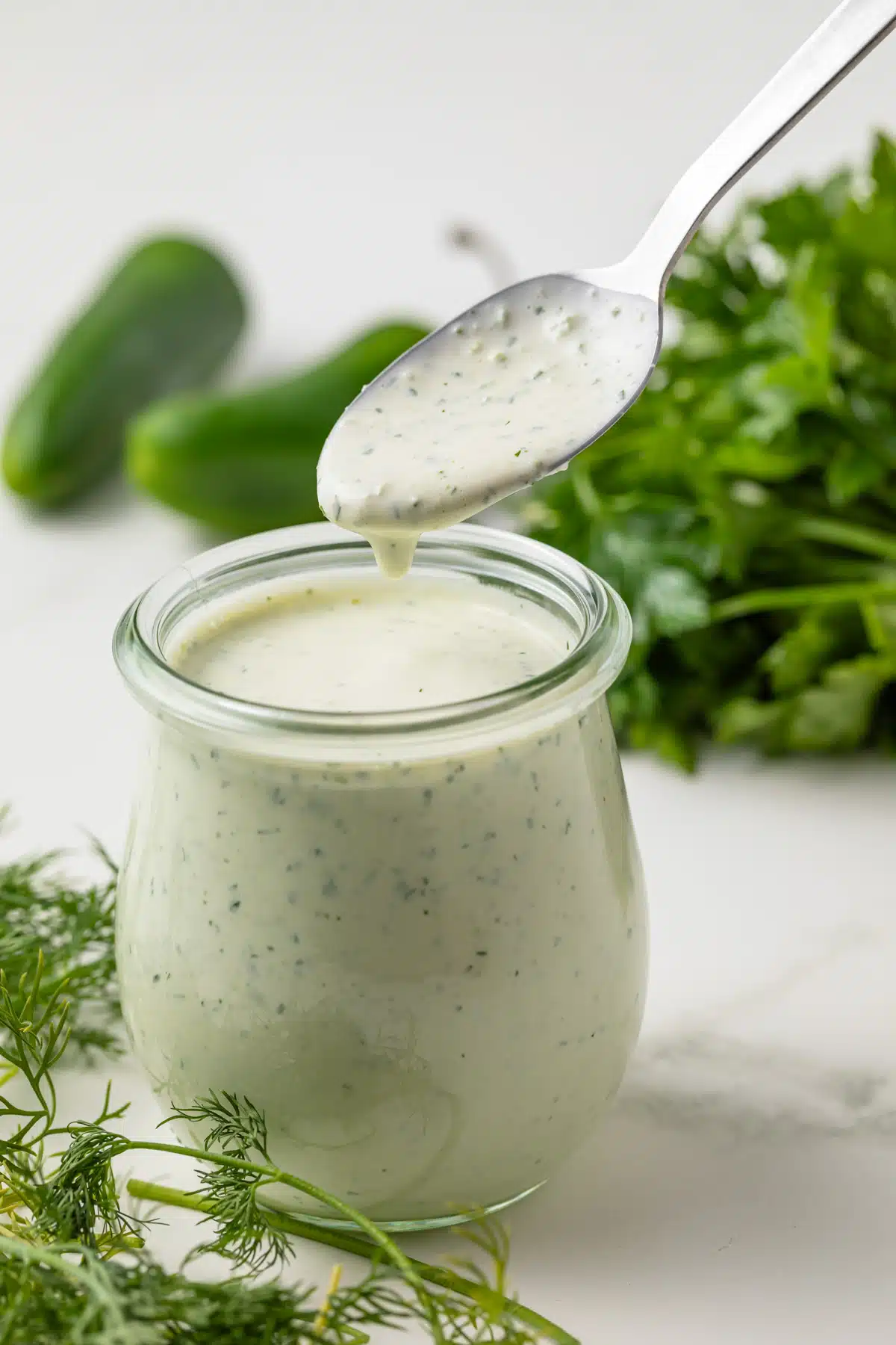 Jalapeno ranch dressing in a glass jar with spoon.
