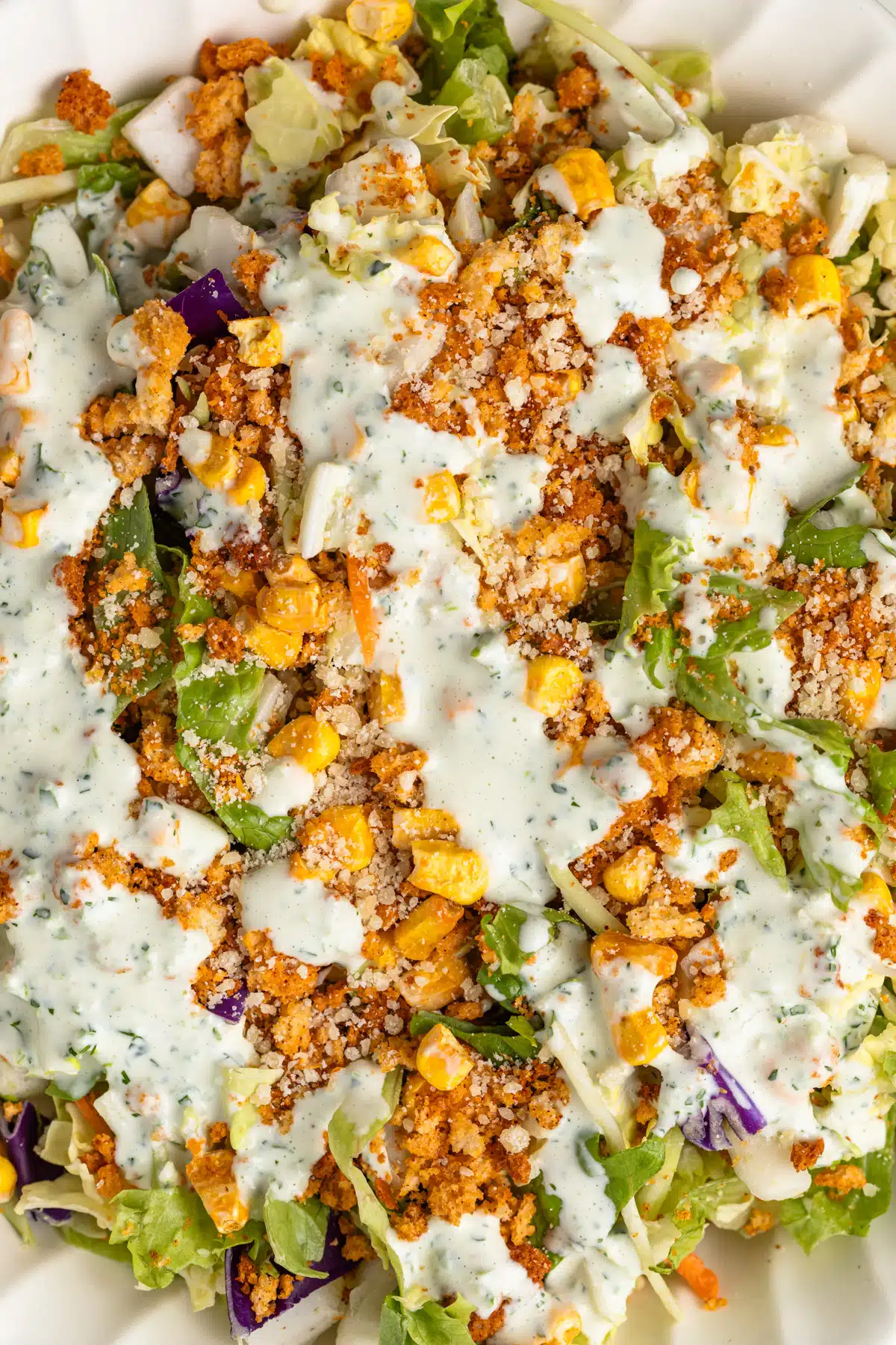 Close up of jalapeno ranch drizzled over salad.