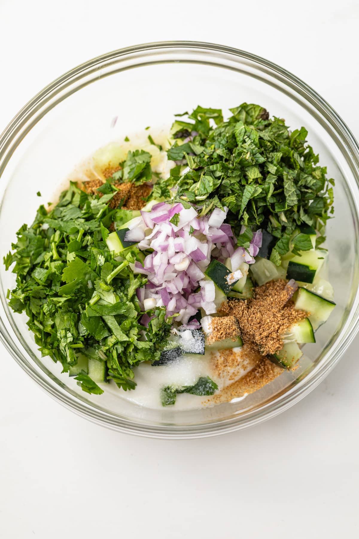 Ingredients for raita in glass bowl.