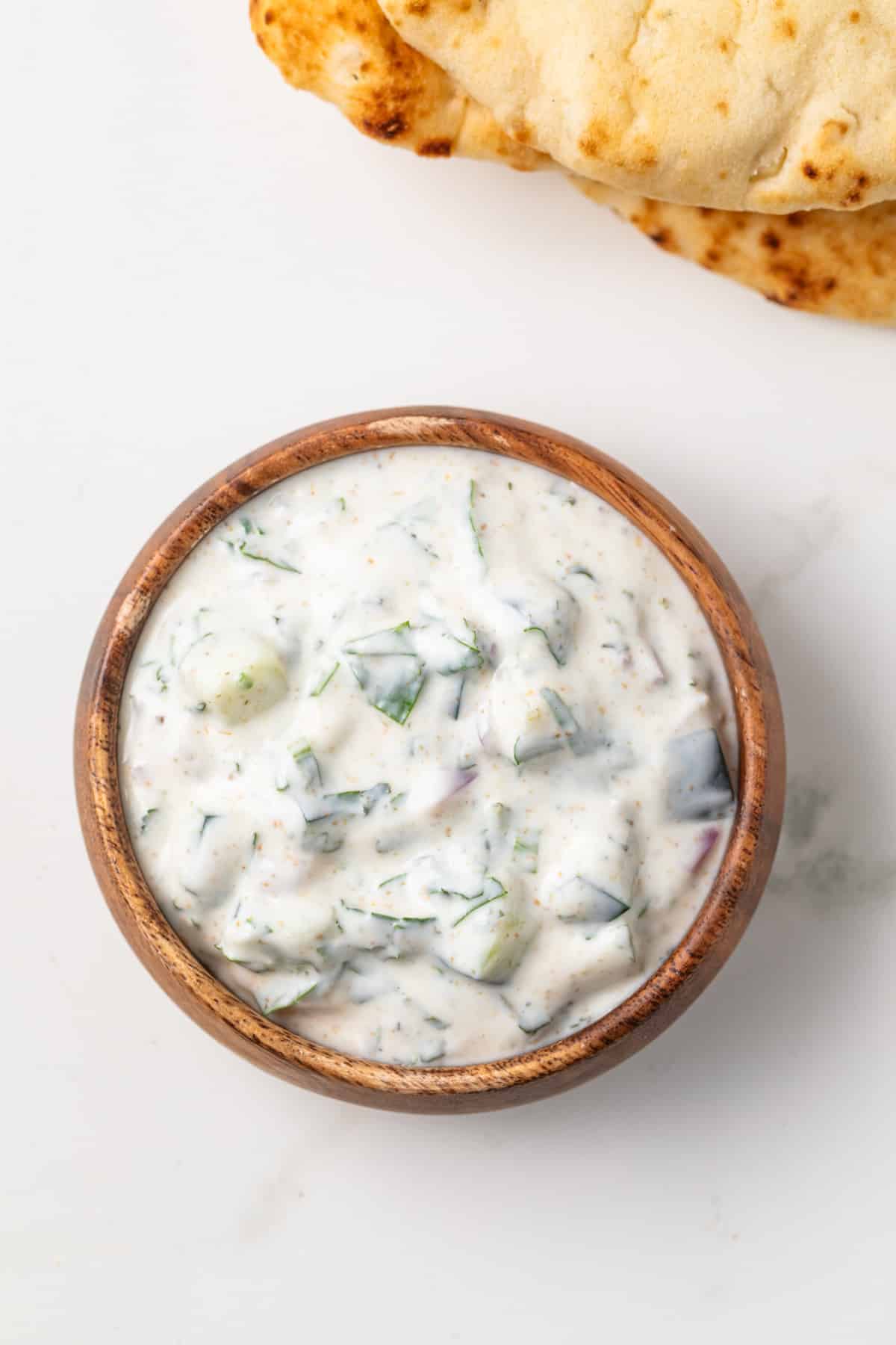 Overhead view of Indian raita in brown bowl.