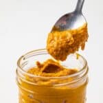 Thai yellow curry paste in a jar with a spoon.