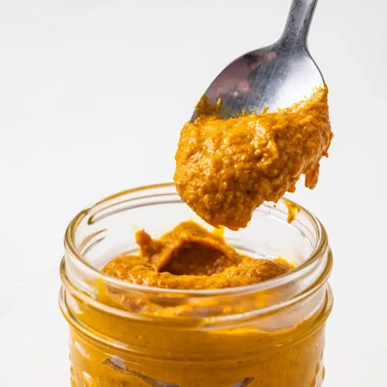 Thai yellow curry paste in a jar with a spoon.