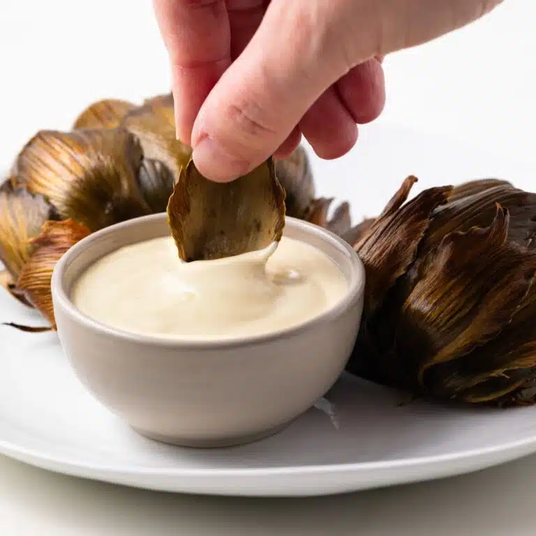 Artichoke petal dipped in artichoke dipping sauce.