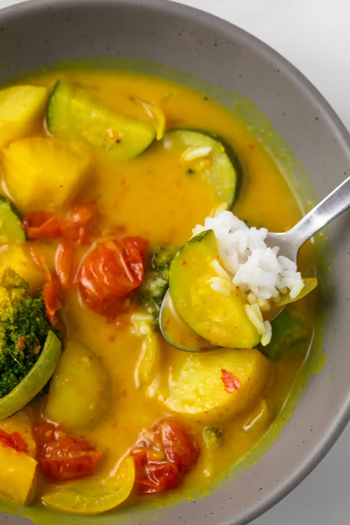 Yellow curry in a bowl with a spoon.
