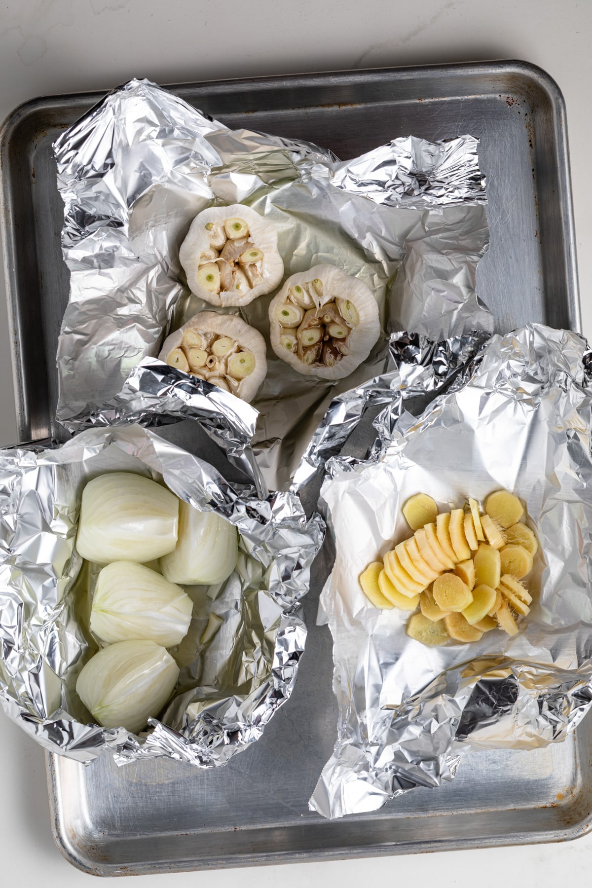 Onion, garlic, and ginger in foil packs.