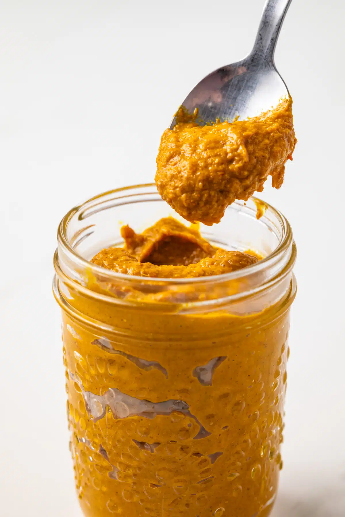 Thai yellow curry paste in a jar with a spoon.