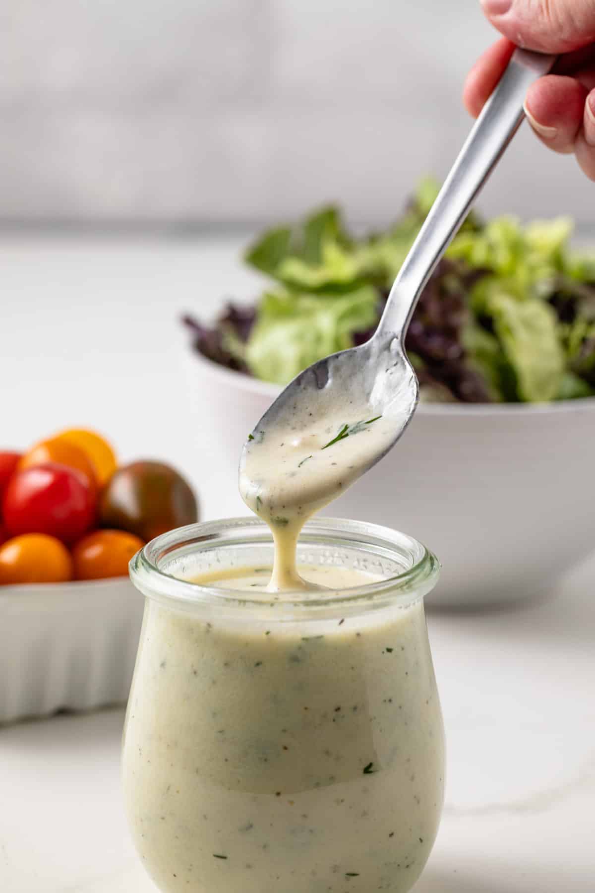 Greek yogurt salad dressing in a jar with a spoon.