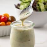 Greek yogurt salad dressing in a jar with a spoon.