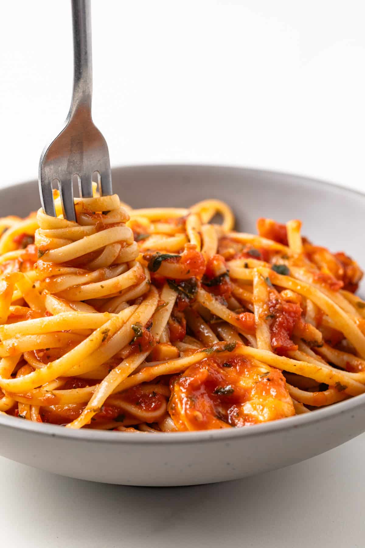 Pasta twirled around a fork in a bowl.