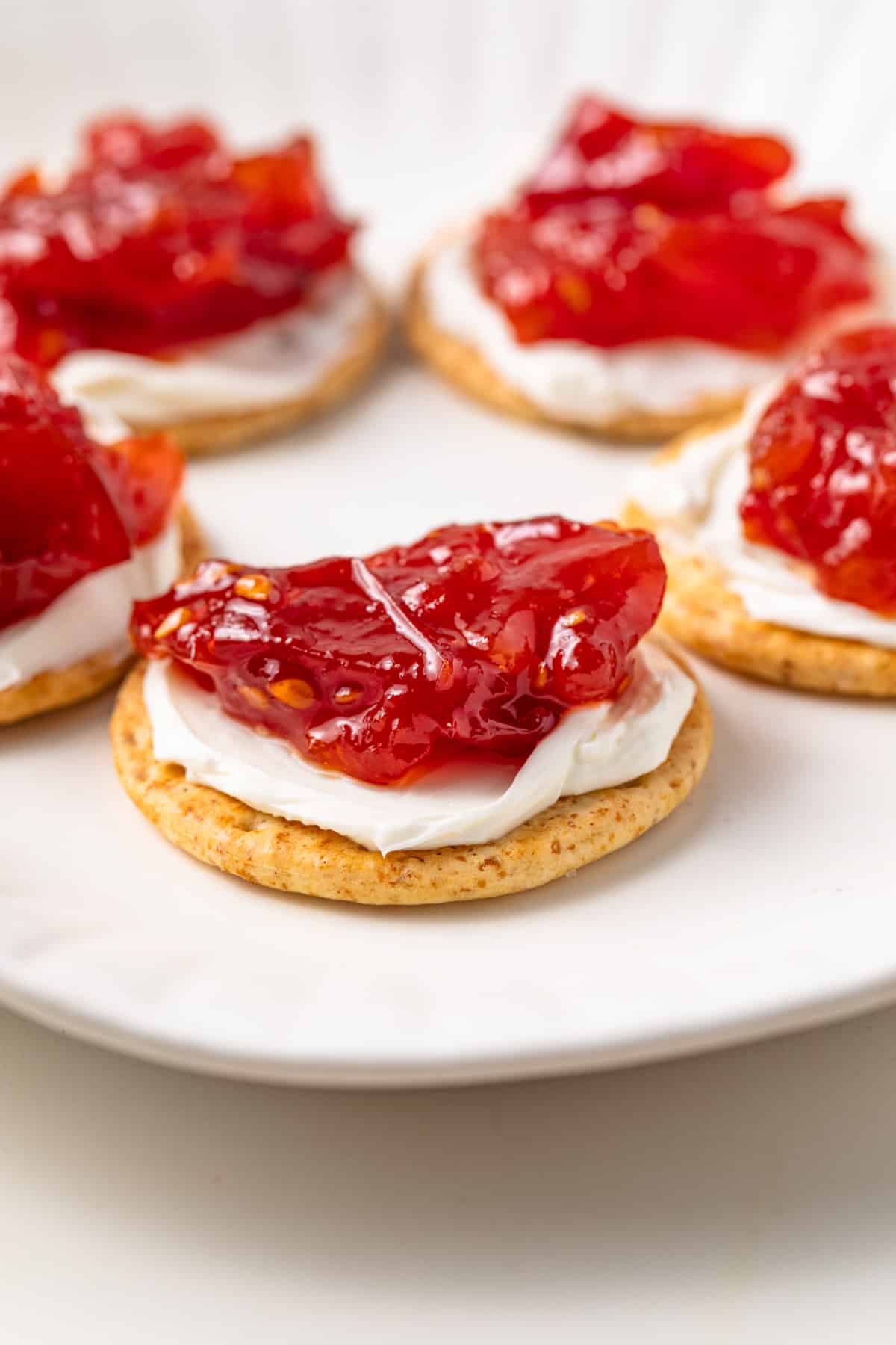 Side view of roasted tomato jam on top of crackers.