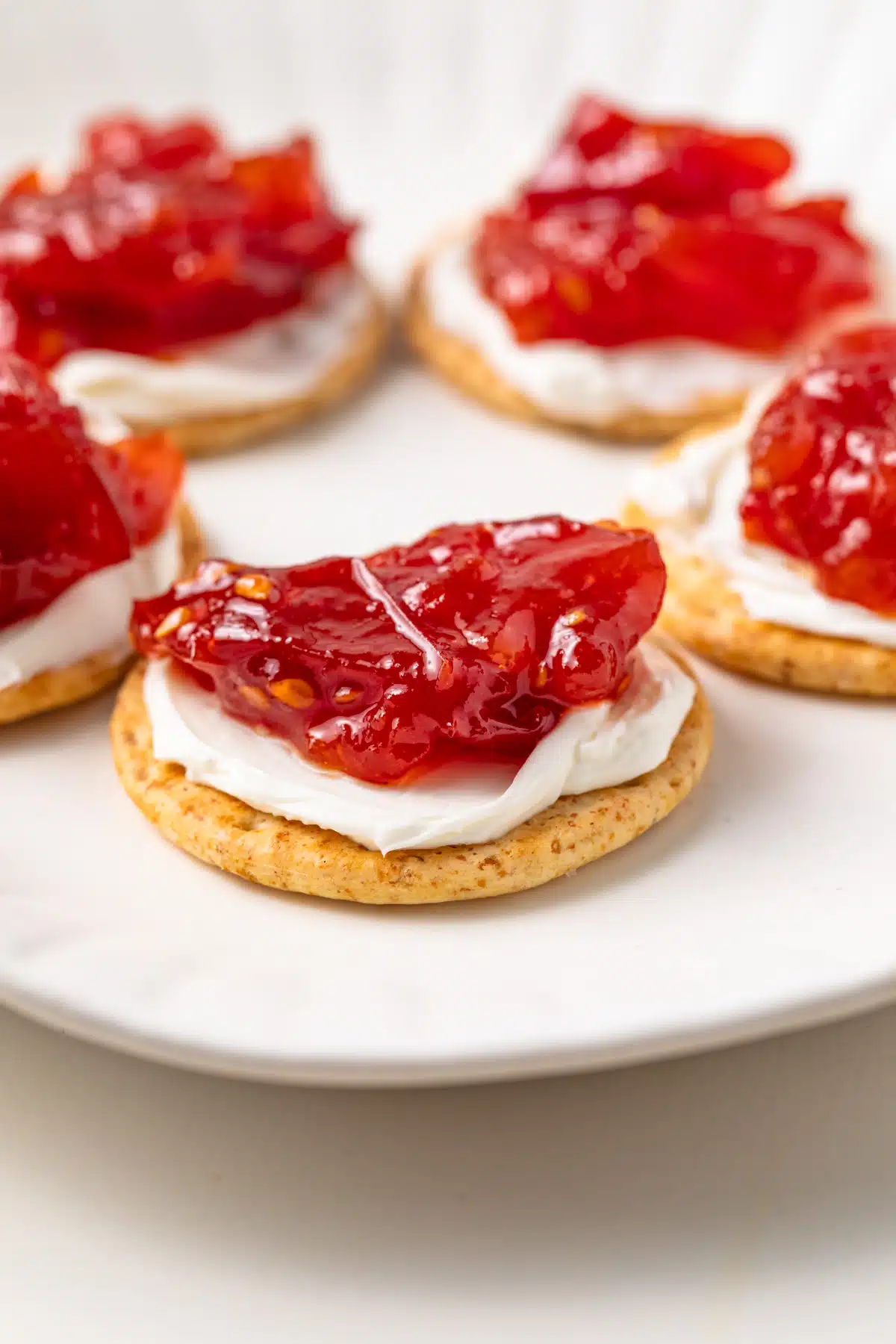 Side view of roasted tomato jam on top of crackers.