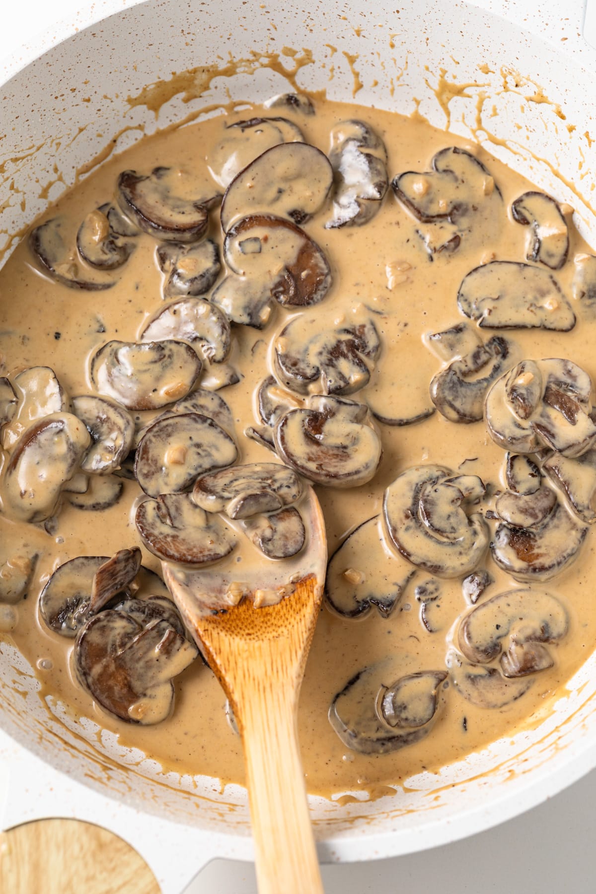 Dijon mushroom sauce in pan with spoon.