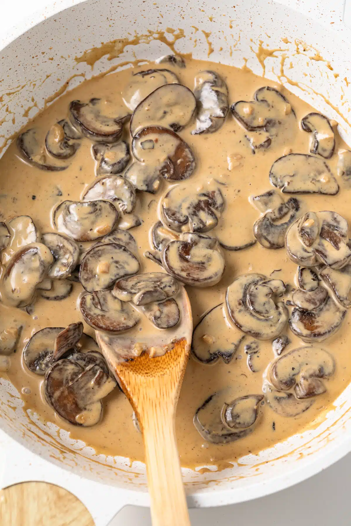 Dijon mushroom sauce in pan with spoon.