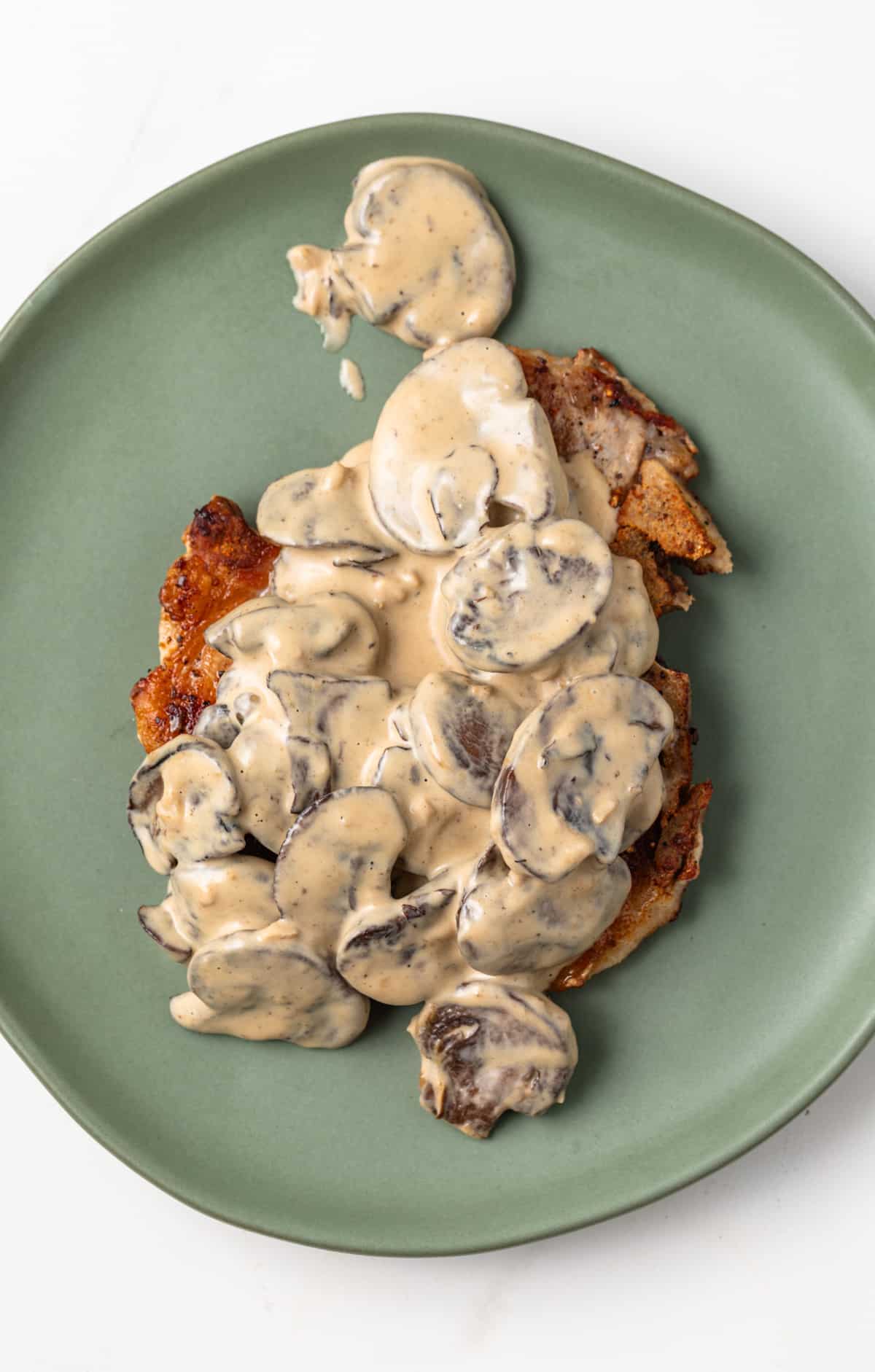 Overhead view of Dijon Mushroom Sauce over fried pork chop.