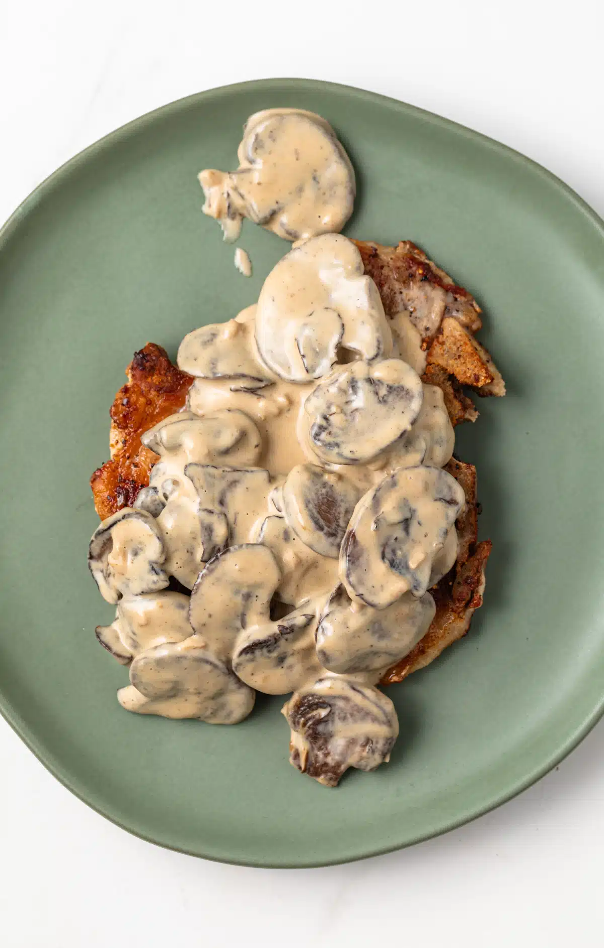 Overhead view of Dijon Mushroom Sauce over fried pork chop.
