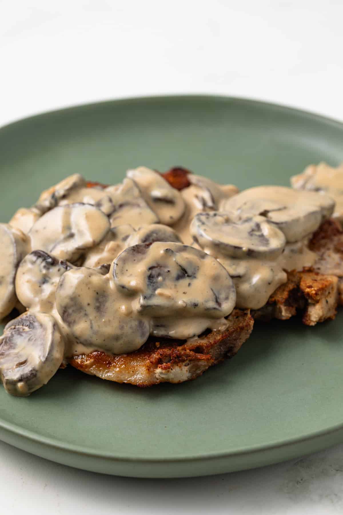 Side view of Dijon Mushroom Sauce over fried pork chop.