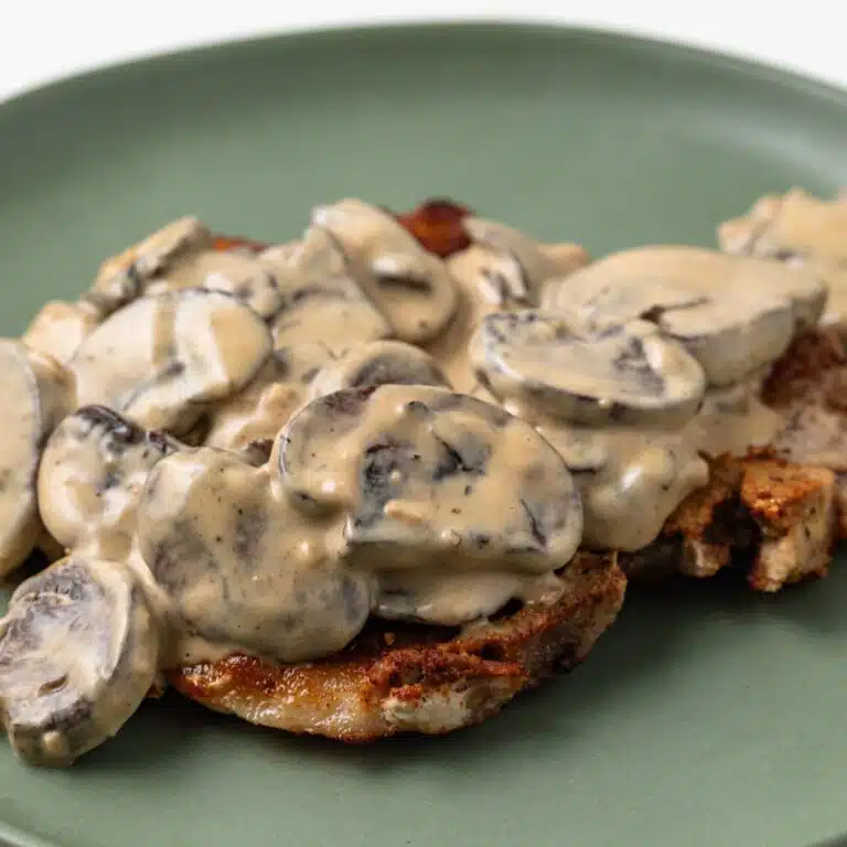 Side view of Dijon Mushroom Sauce over fried pork chop.
