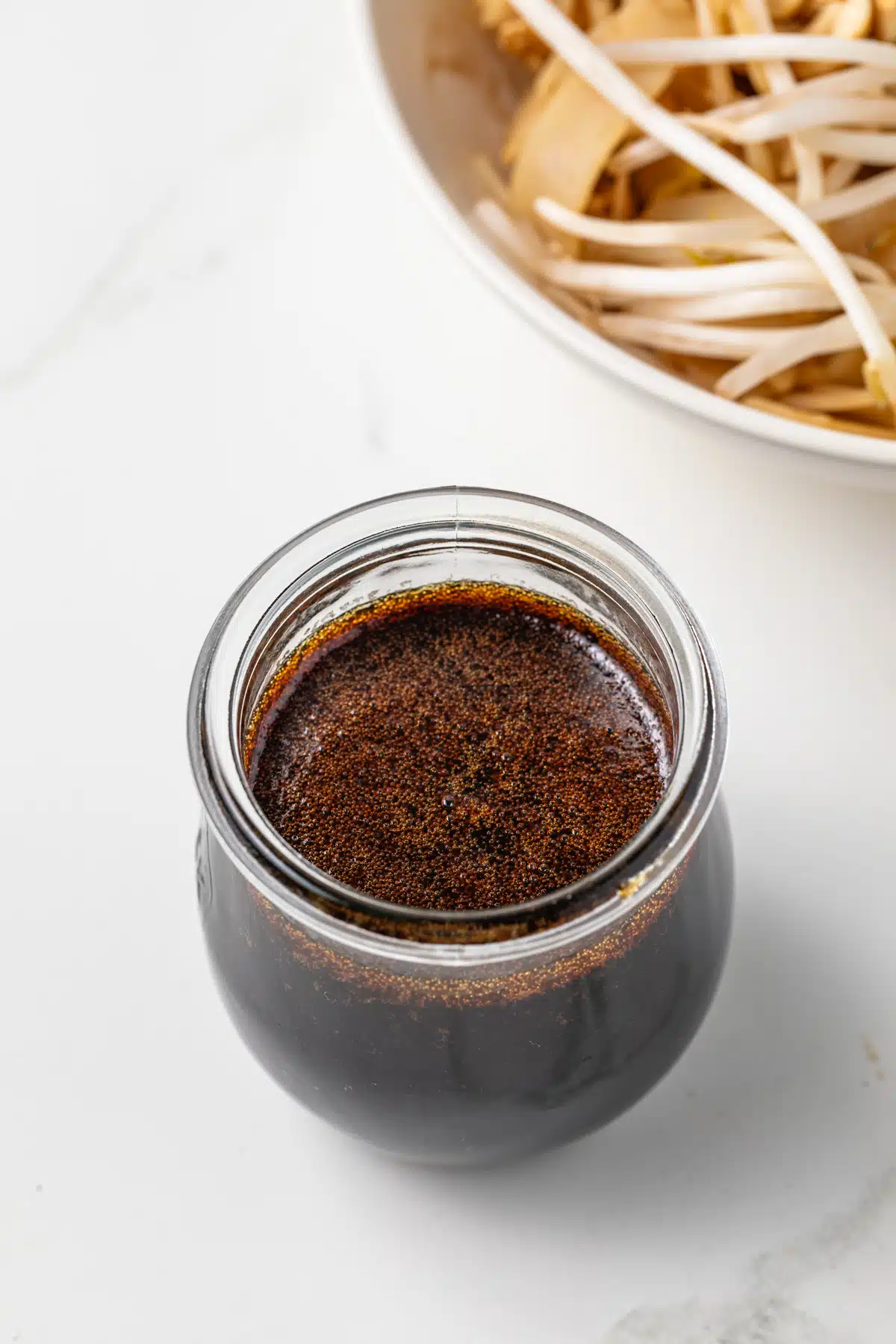 Angled view of Pad Thai sauce in a glass jar.