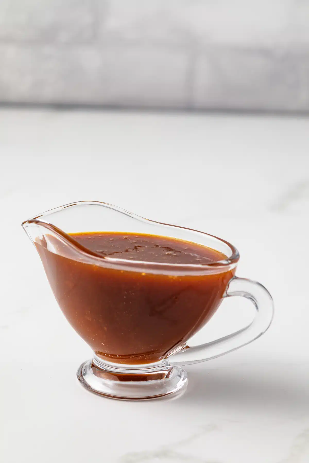 Buttermilk caramel sauce in a glass gravy boat.