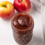 High angled view of slow cooker apple butter in a jar.