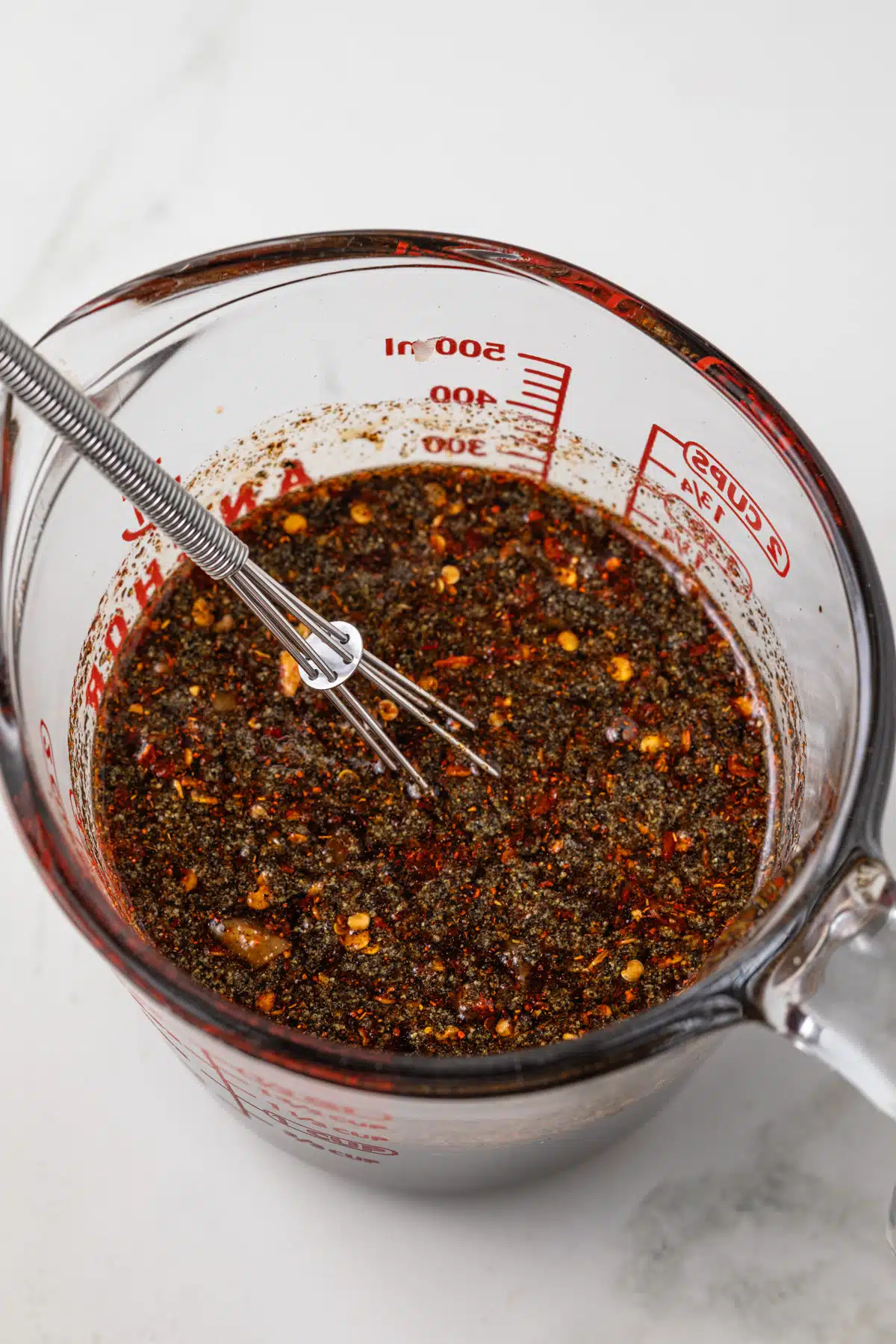 Spicy steak marinade in liquid measuring cup.