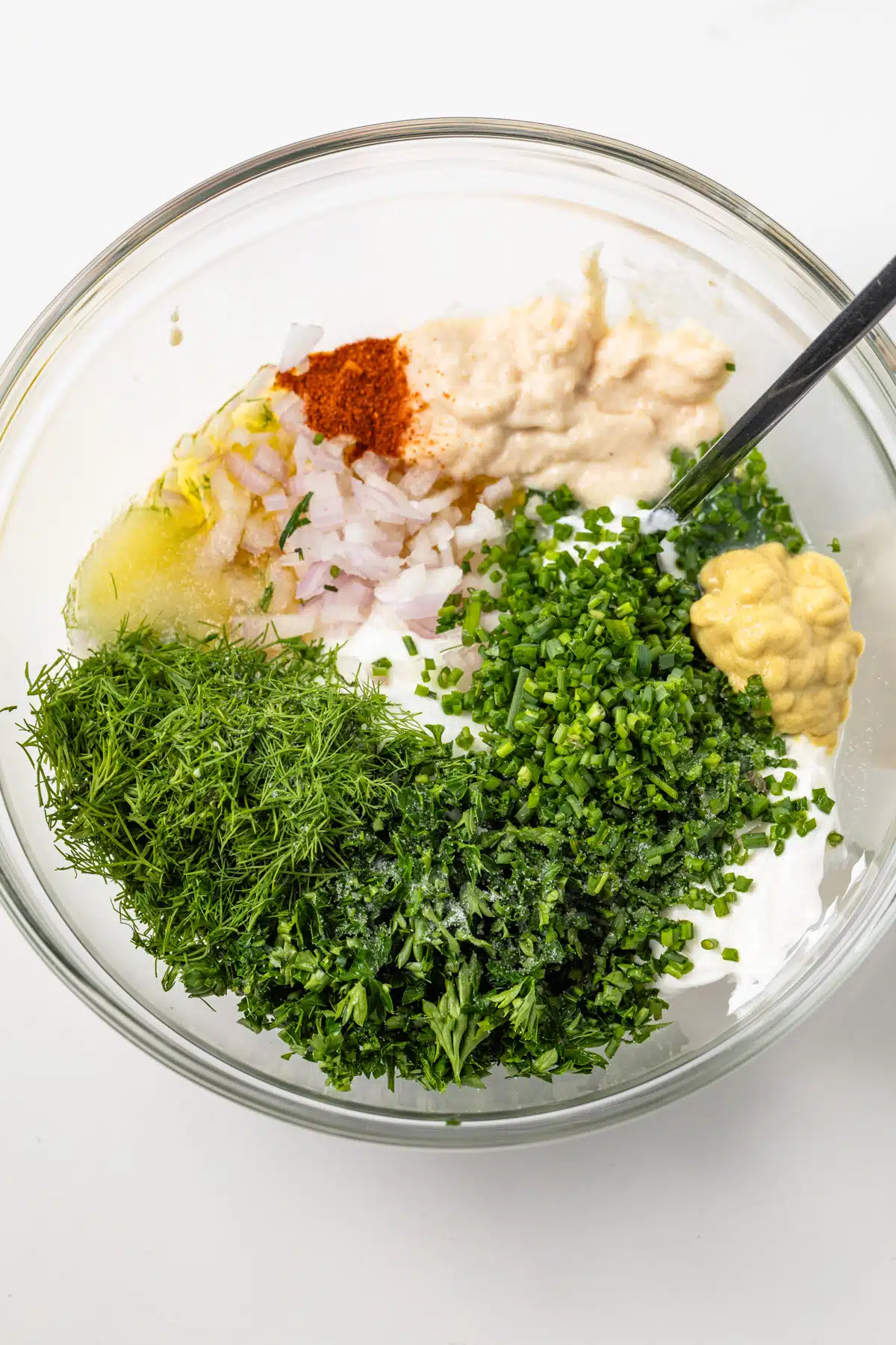 Ingredients for creamy herb sauce in a bowl.